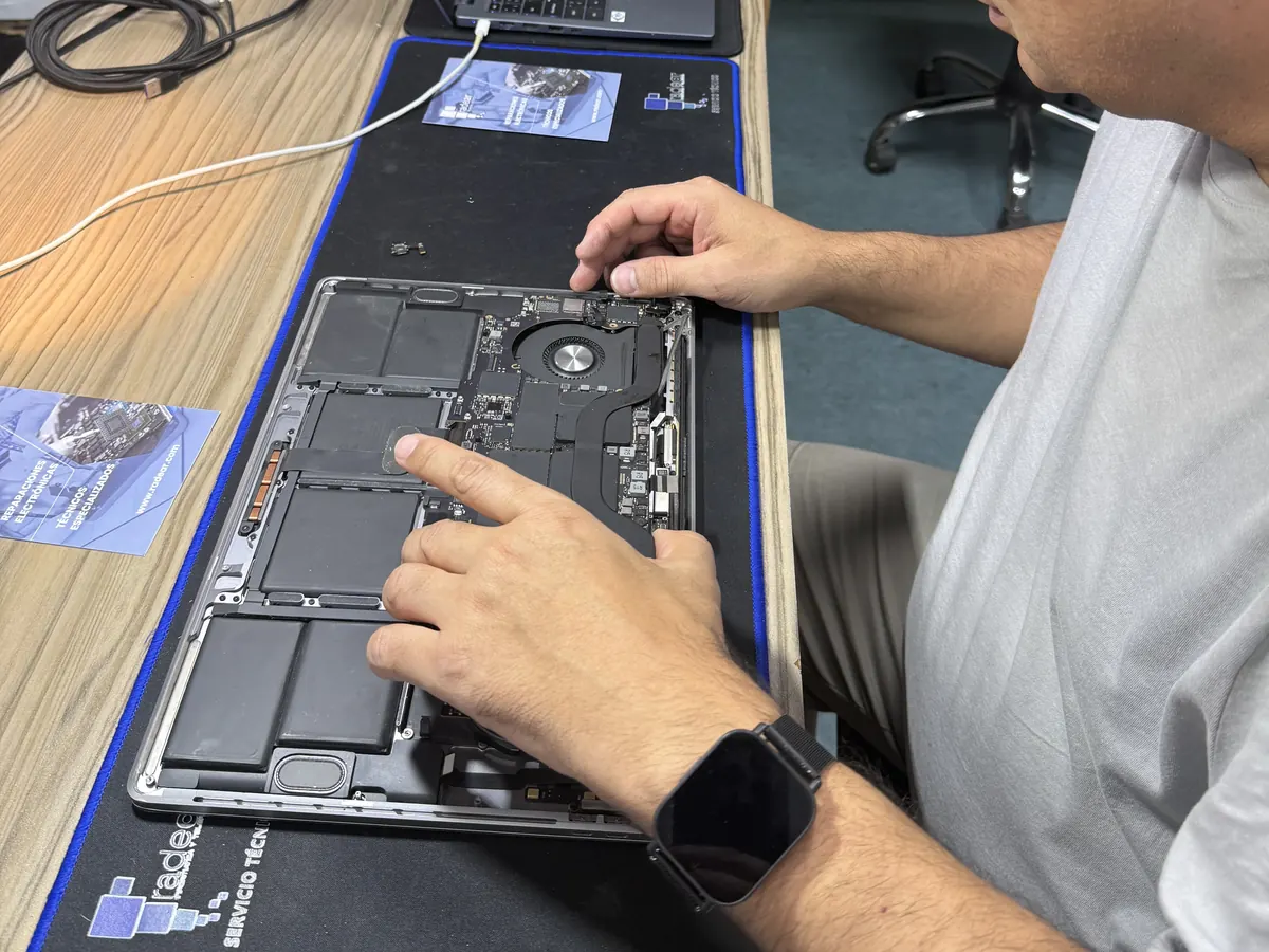 Técnico de Radear revisando un portátil abierto en el taller de Alicante
